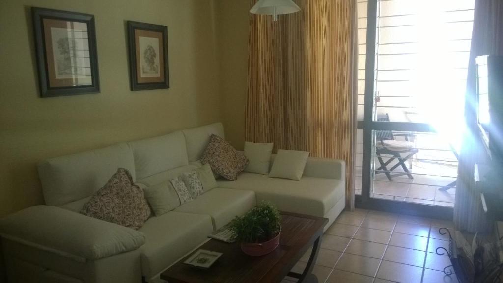 uma sala de estar com um sofá branco e uma mesa em Islantilla Centro Primera Linea em Islantilla