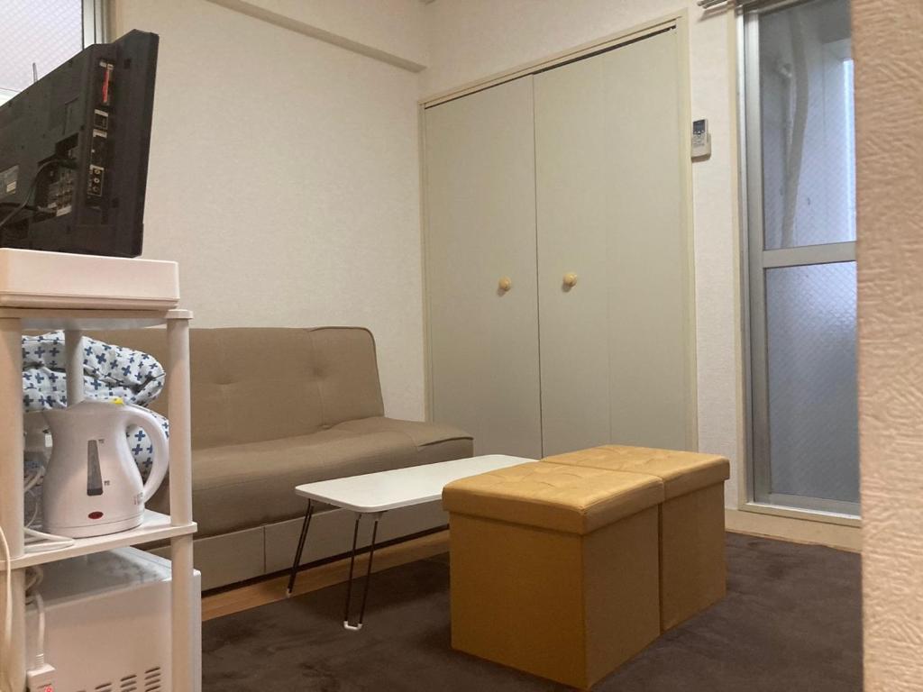 uma sala de estar com um sofá e uma mesa em Cocone house Ohoripark em Fukuoka