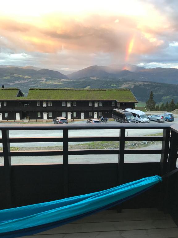 a view of a rainbow from a balcony with a bench at Voss, Øvre Tråstølen in Skulestadmo