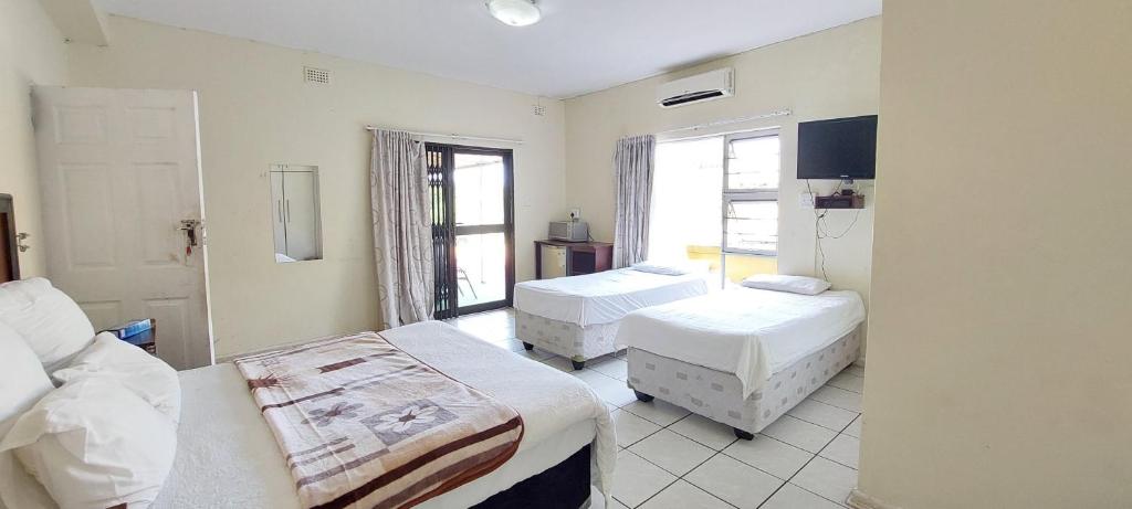 1 Schlafzimmer mit 2 Betten und einem Fenster in der Unterkunft Luxury stays in Empangeni