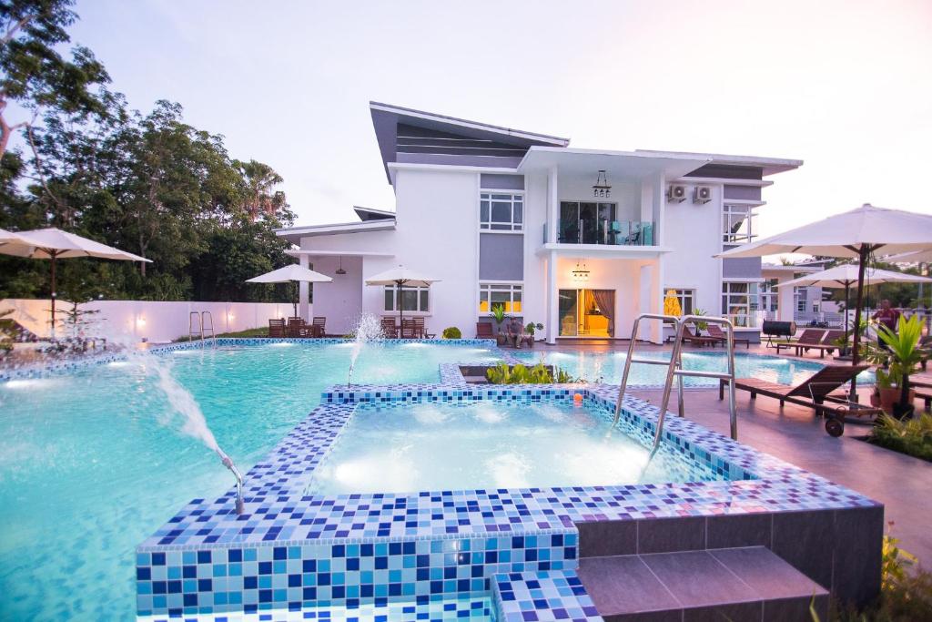 a swimming pool with a fountain in front of a house at The Duyong Dream in Melaka