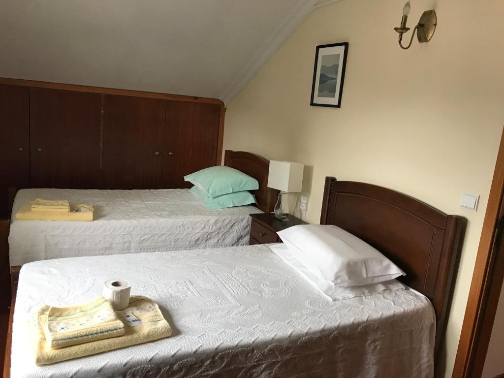 a hotel room with two beds and a tray with a book at casa largo do cruzeiro in Peso da Régua