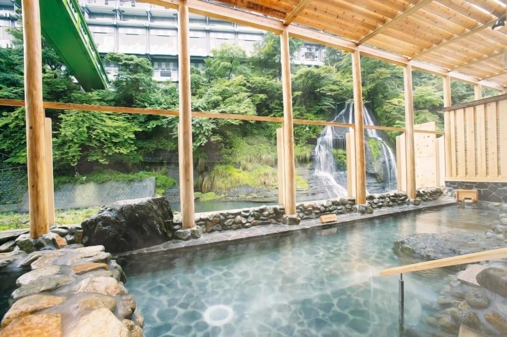 a swimming pool with a waterfall and a water park at Ooedo Onsen Monogatari Hotel New Shiobara in Nasushiobara