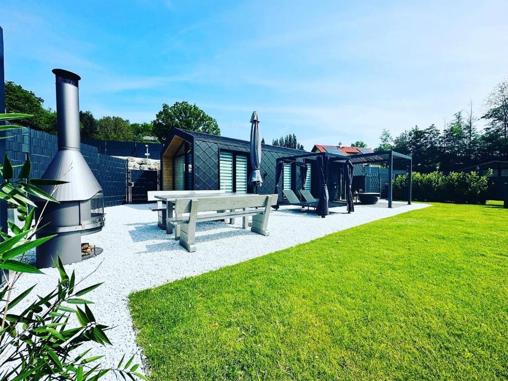 een achtertuin met een picknickbank en een huis bij Voralpen Lodge - Ferienhaus mit Gym & Wellnessbereich in Traisen