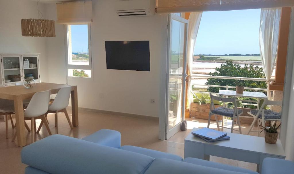 sala de estar con sofá azul y mesa con vistas en La Savina Ses Platgetes, en La Savina