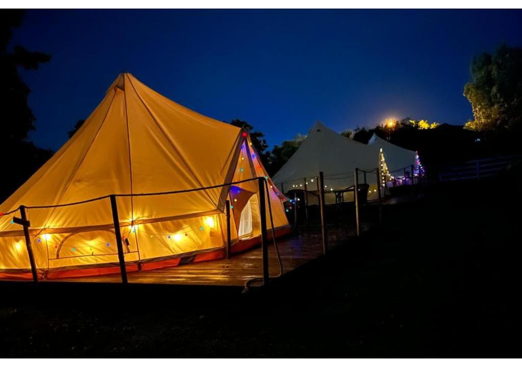 a large tent is lit up at night at Grădina Magică a Lavandei Glamping in Urlaţi