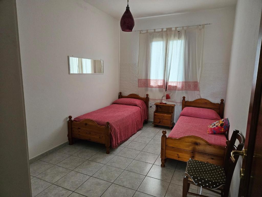 1 Schlafzimmer mit 2 Betten und einem Fenster in der Unterkunft Casa di Ale in Siniscola