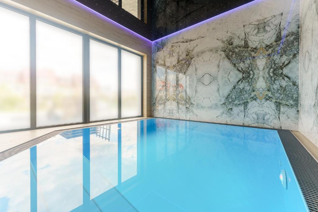 a swimming pool with a wall of windows at Mielno Hotel Boutique in Mielno