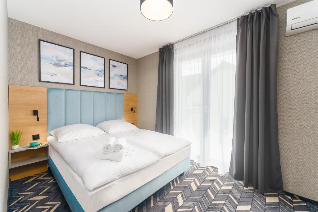 梅爾諾的住宿－Mielno Hotel Boutique，一间卧室配有一张大床和两条毛巾