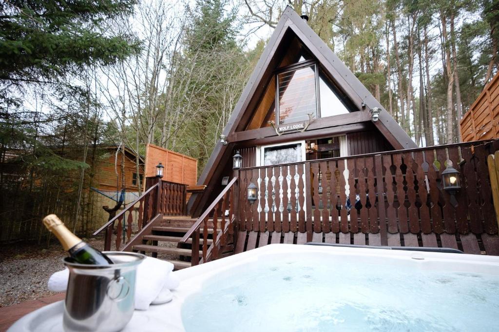 a tree house with a hot tub in the backyard at Wolf Lodge in Carrbridge