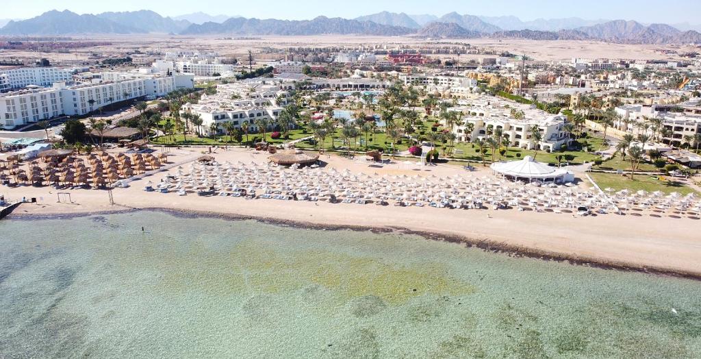 eine Luftansicht auf einen Strand mit Stühlen und Sonnenschirmen in der Unterkunft Regency Plaza Aqua Park and Spa Resort in Sharm El Sheikh