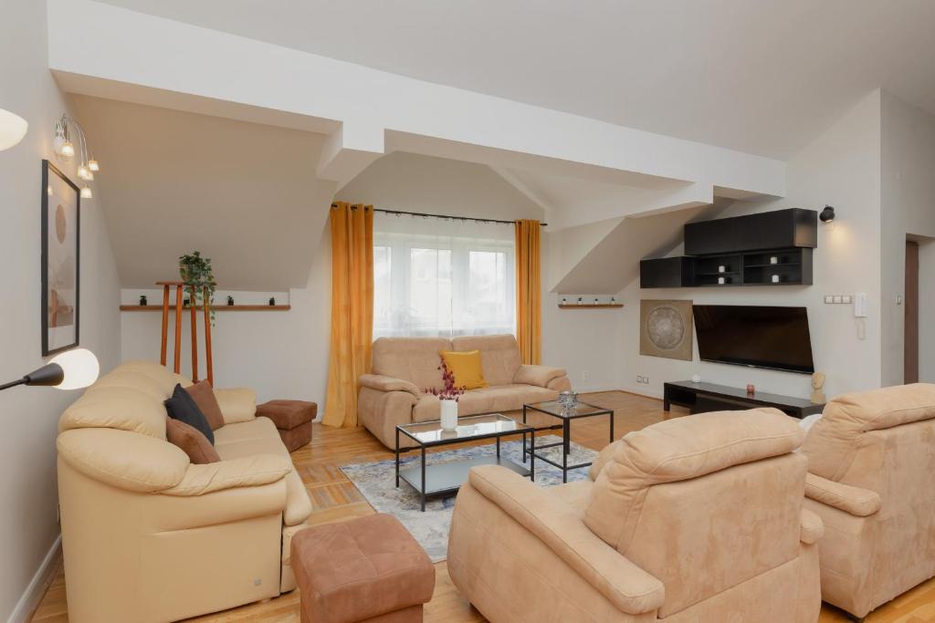 a living room with two couches and a tv at Spacious Apartment for 8 Guests near Metro Natolin by Renters in Warsaw