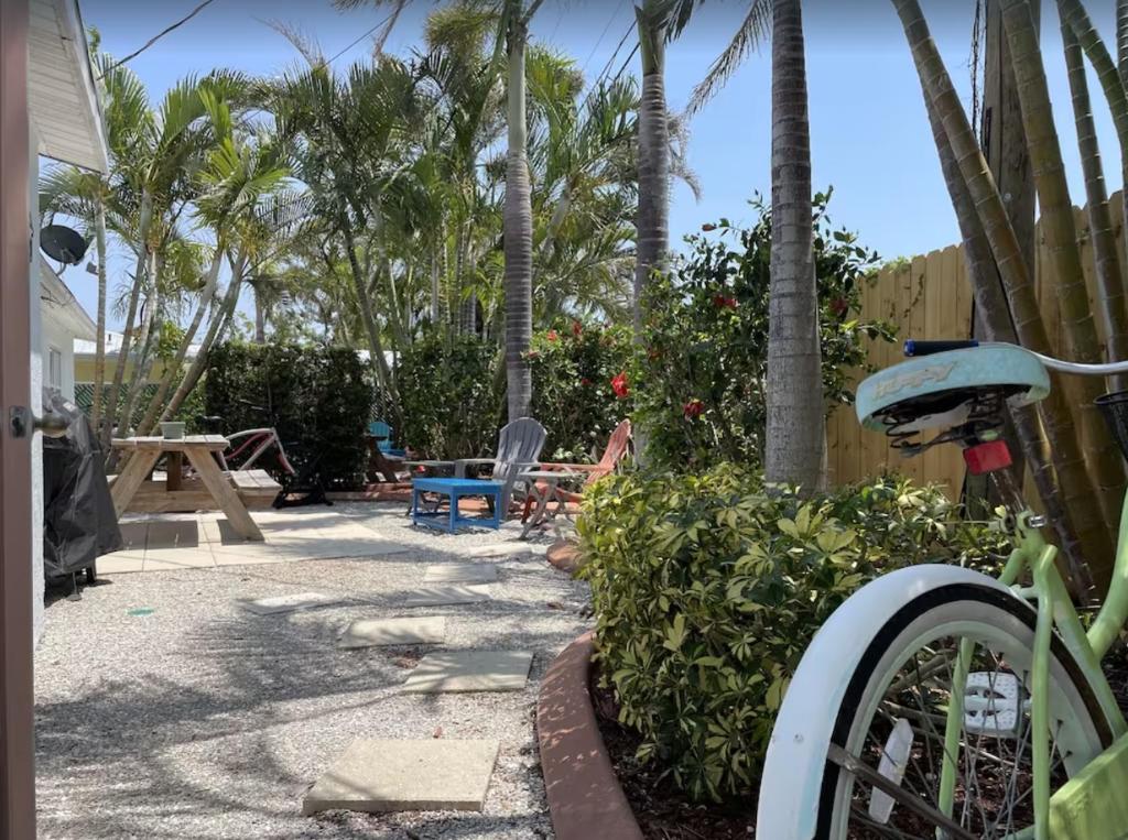 a backyard with a table and chairs and palm trees at Manasota Key Cottage B in Englewood
