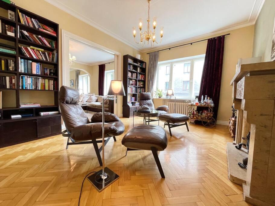 ein Wohnzimmer mit Stühlen, einem Tisch und Bücherregalen in der Unterkunft Spacious apartment in city center in Tallinn