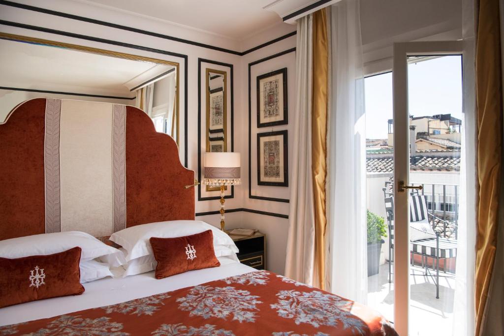 ein Schlafzimmer mit einem großen Bett und einem Balkon in der Unterkunft Hotel d’Inghilterra Roma – Starhotels Collezione in Rom