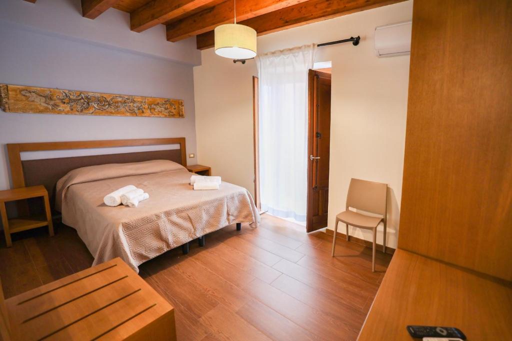 1 dormitorio con 1 cama con 2 toallas en Camere U Campanaru, en Gratteri