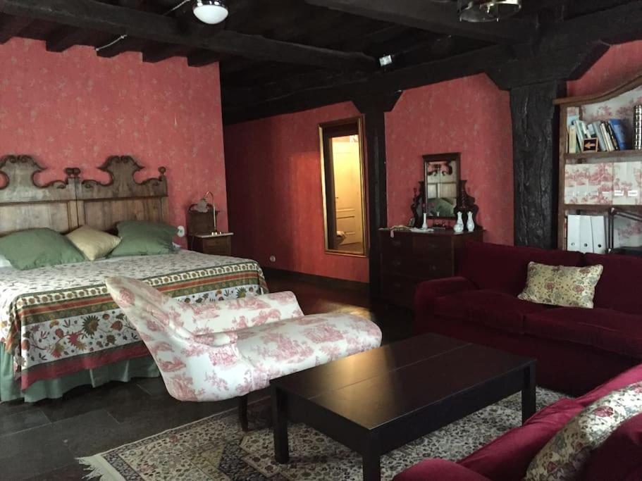 1 dormitorio con cama, sofá y mesa en Casa rural con piscina privada, en Casar de Palomero