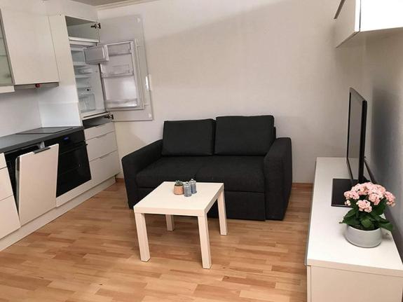 uma sala de estar com um sofá preto e uma mesa em Apartment in Åsane em Bergen