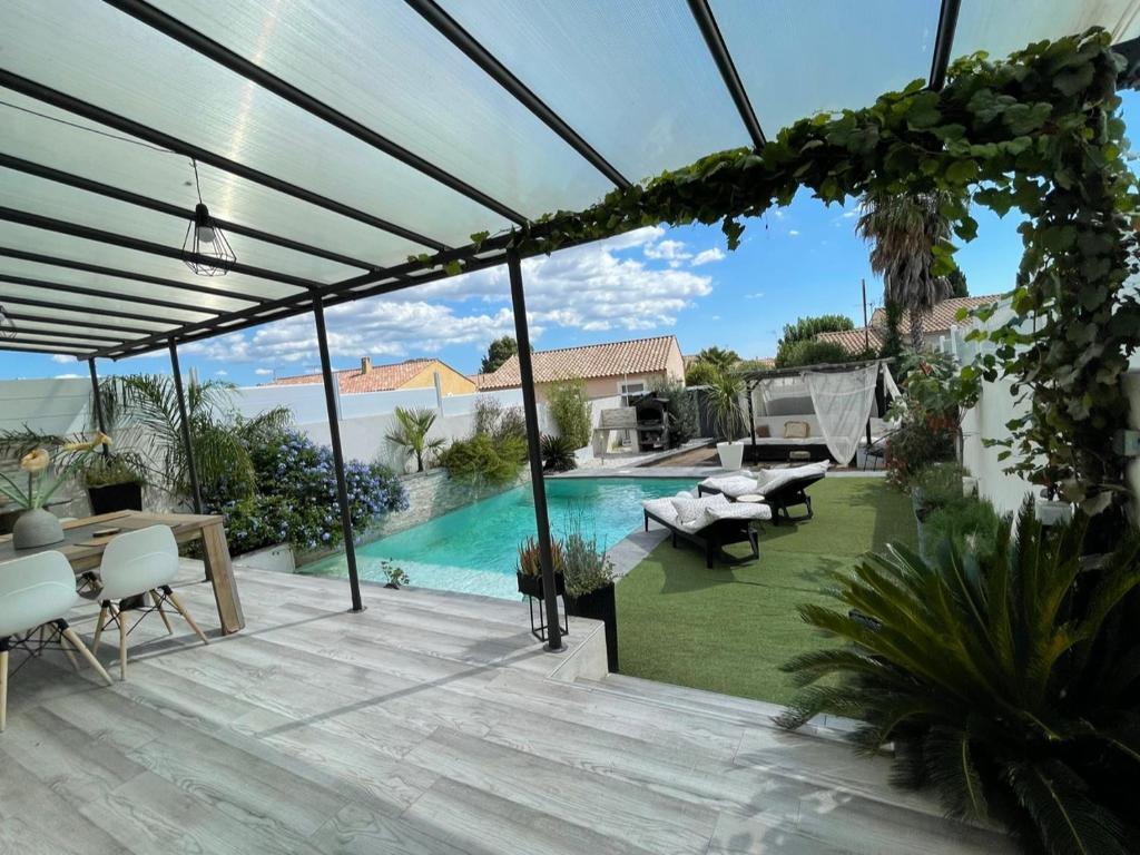 a patio with a view of a swimming pool at Villa avec piscine au calme 6 personnes in Valros