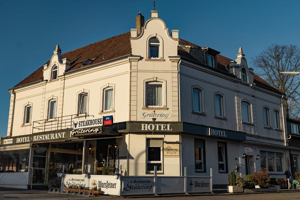 ein großes weißes Gebäude an der Ecke einer Straße in der Unterkunft Hotel Grütering in Dorsten