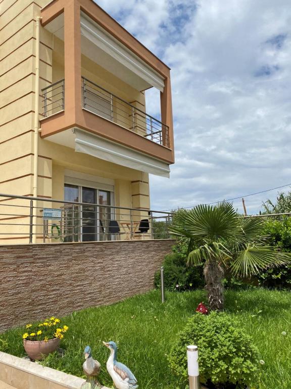 a house with two birds in front of it at Efrosini's Home in Néa Michanióna