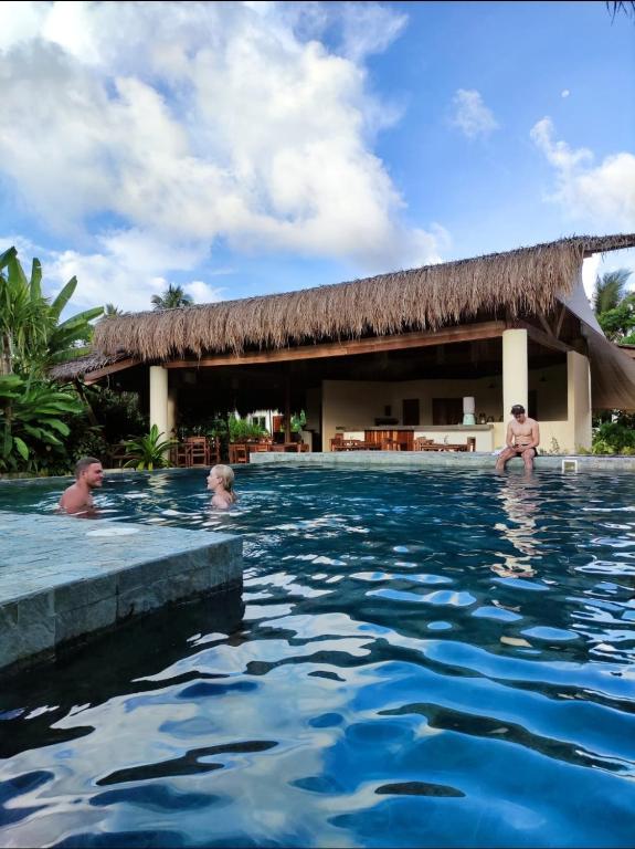 un gruppo di persone nella piscina di un resort di Tropical Bungalows-Siargao a General Luna