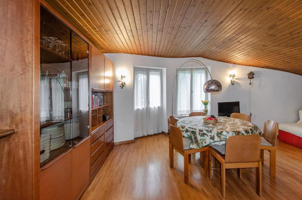 ein Esszimmer mit einem Tisch und ein Schlafzimmer in der Unterkunft Spazioso appartamento centrale con wi-fi in Cortina d'Ampezzo