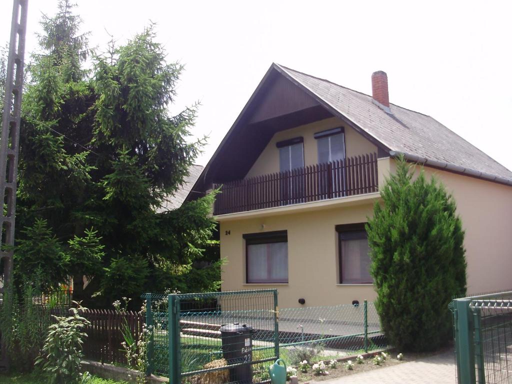 uma casa com uma varanda em cima em Szatmári Vendégház em Balatonlelle