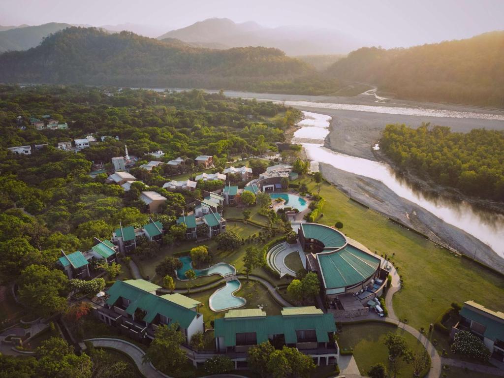 eine Luftansicht eines Resorts neben einem Fluss in der Unterkunft Namah Resort Jim Corbett, a member of Radisson Individuals in Rāmnagar