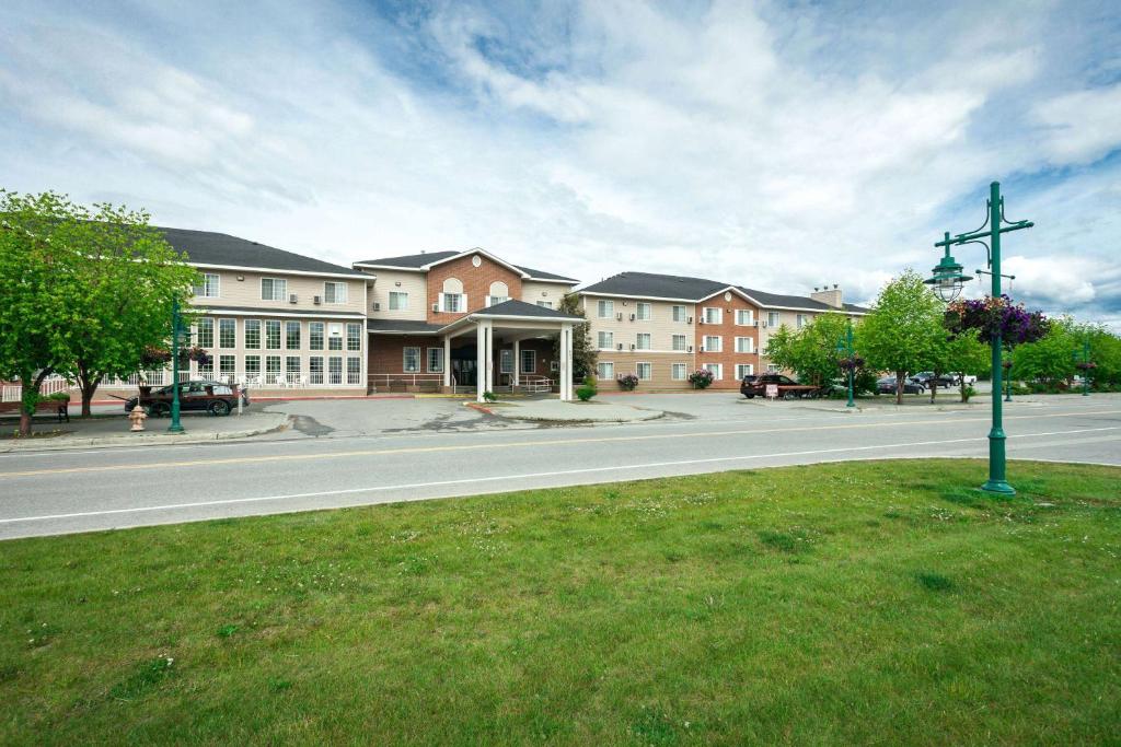 a building on a street with a pole in the grass at Wingate by Wyndham Anchorage Downtown - Ship Creek in Anchorage