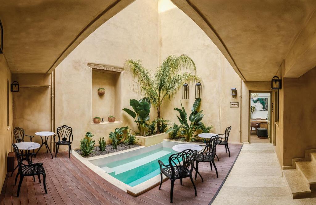 een zwembad in een kamer met stoelen en een tafel bij Casa di Gaga in Rethimnon