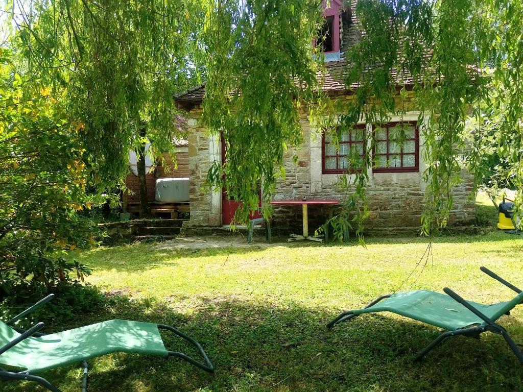 une maison avec deux chaises de jardin devant elle dans l'établissement Maison de poupée et son SPA privatif, à Orthez