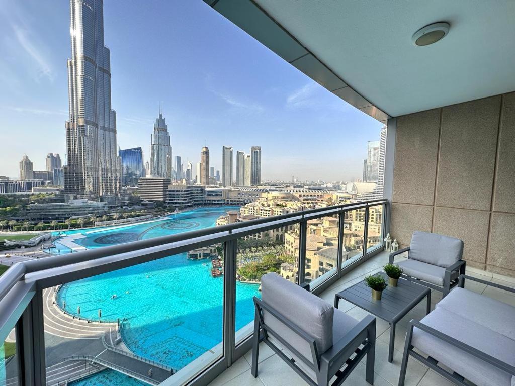a balcony with a swimming pool and a view of a city at Durrani Homes - Grand 5BR besides Burj khalifa and Fountain view in Dubai