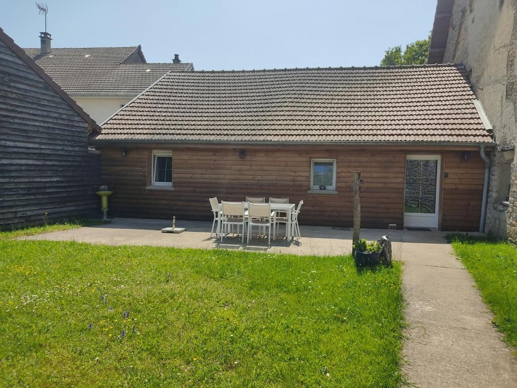a table and chairs in front of a building at Gîte des trois petits oiseaux in Picarreau