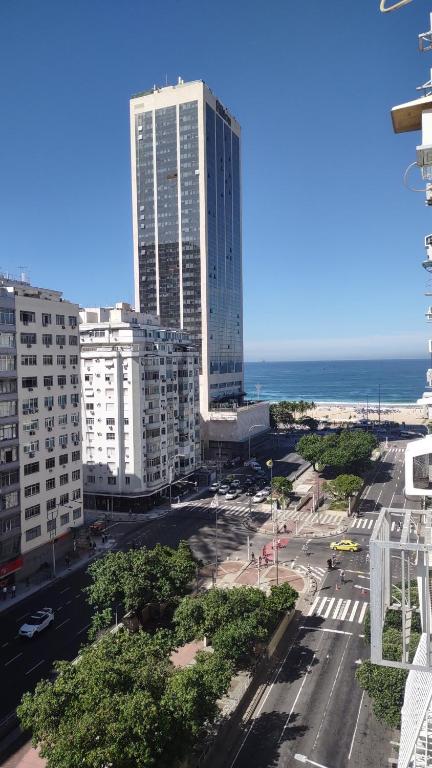 a view of a city with a tall building and the ocean at Temporada Copacabana Salu in Rio de Janeiro