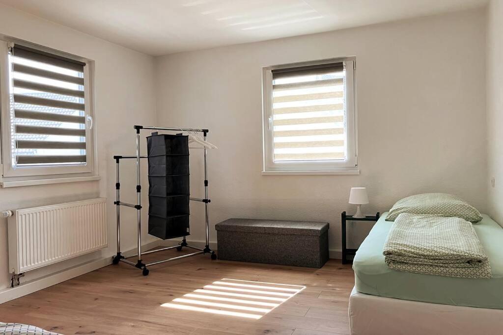 um quarto com uma cama e duas janelas em Großes Ferienhaus in Singhofen 