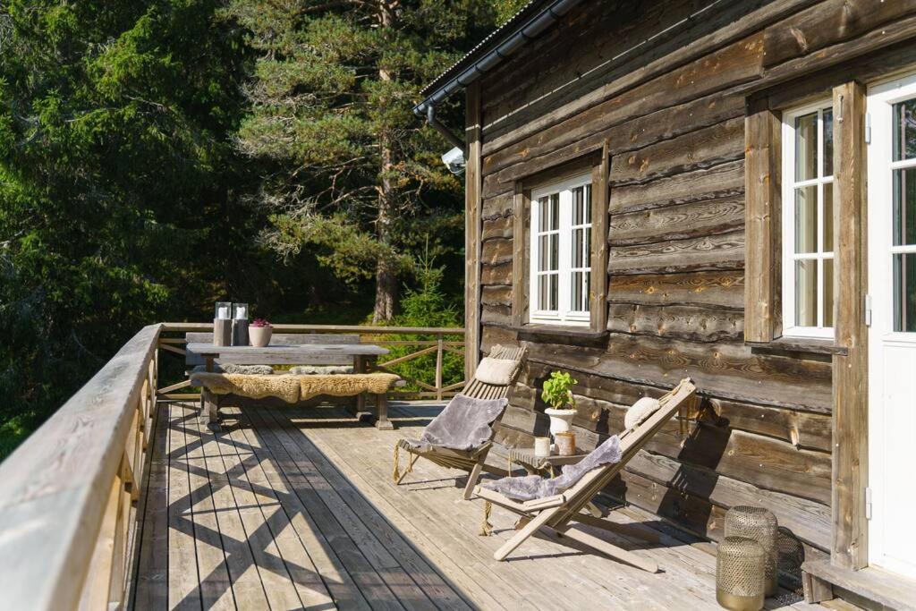 Tjørhom的住宿－Koselig hytte med sjel på fjellet :)，小木屋设有椅子和一张桌子,位于甲板上