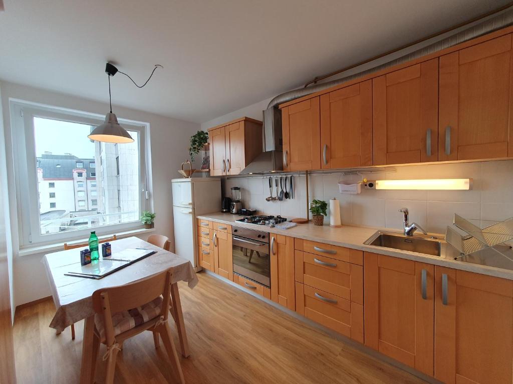 a kitchen with wooden cabinets and a table and a window at Apartment Zala with free parking Tour As Ljubljana in Ljubljana