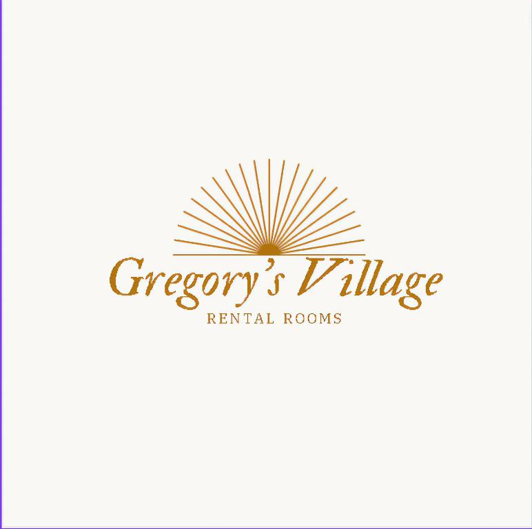 a sign for a hotel with a sunburst logo at Gregory's Village in Platy