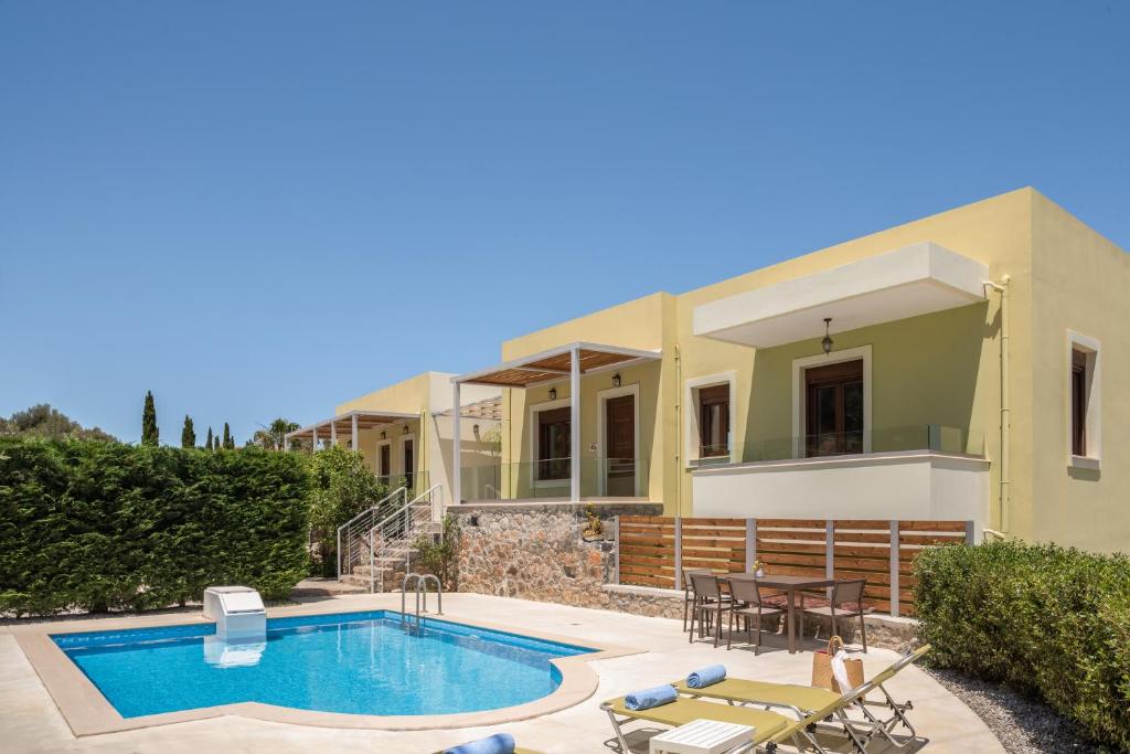 a villa with a swimming pool and a house at Mela Villas in Maroulás
