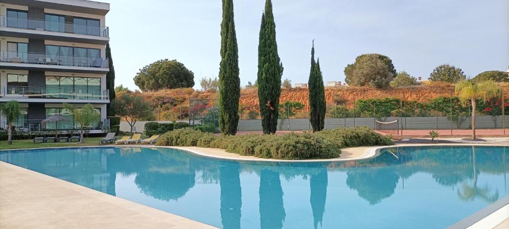 a swimming pool with trees and a building at RESIDENCE GOLF CLUB 415 in Quarteira