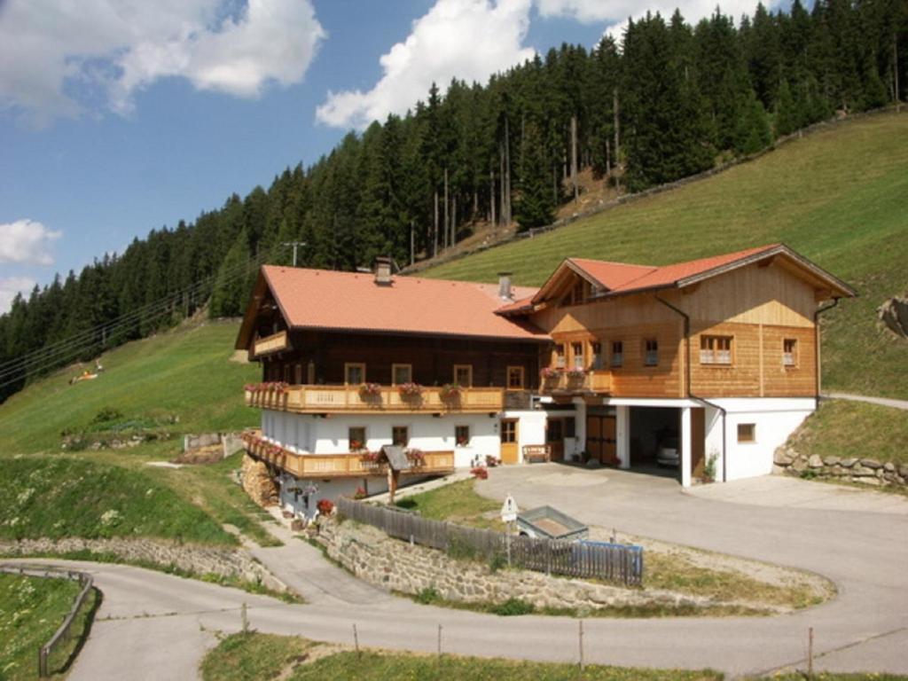 ein Haus auf einem Hügel mit einer Straße davor in der Unterkunft Schuistlhof in Sillian