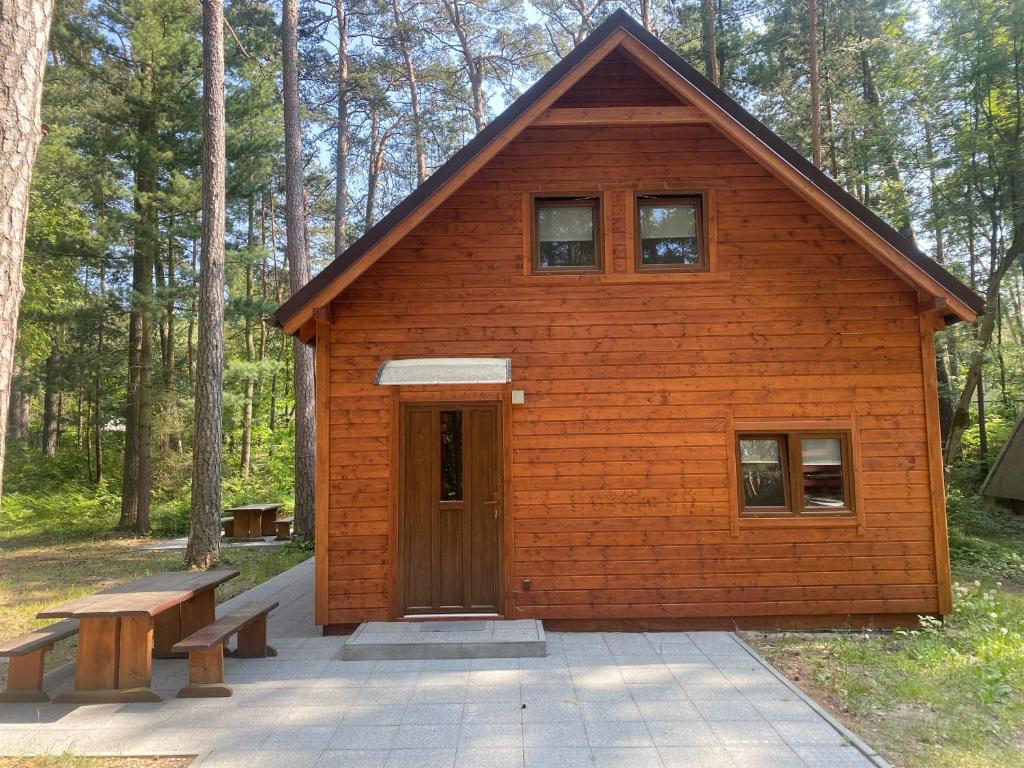 斯蒂格纳Domki Pod Sosnami的一座小木屋，前面有长椅