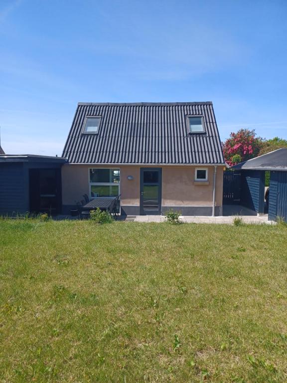 een huis met een dak boven een tuin bij Tæbring Holiday Home in Nykøbing Mors