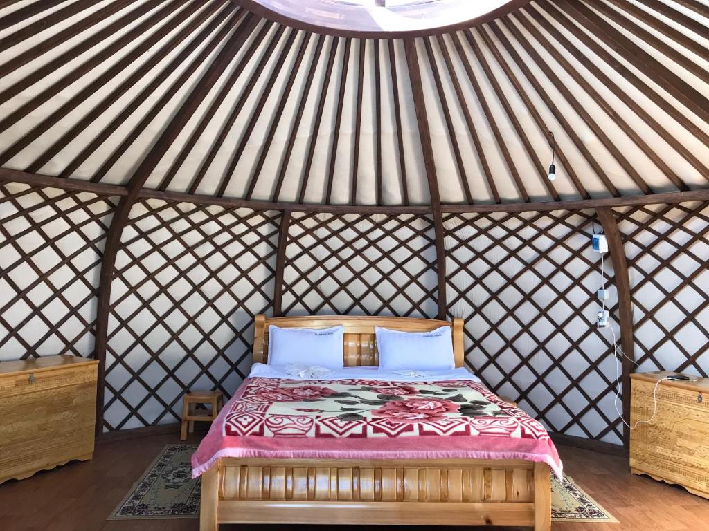 ein Schlafzimmer mit einem Bett in einer Jurte in der Unterkunft Talbiun Lodge in Hujirt