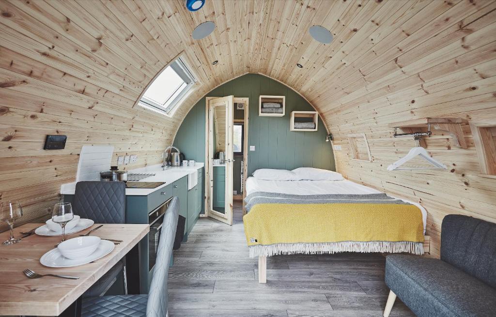 um quarto com uma cama e um lavatório num quarto em Iona Pods em Iona