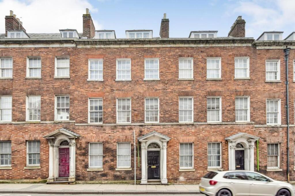 a large brick building with a car parked in front at Flat in the Heart of Worcester in Worcester