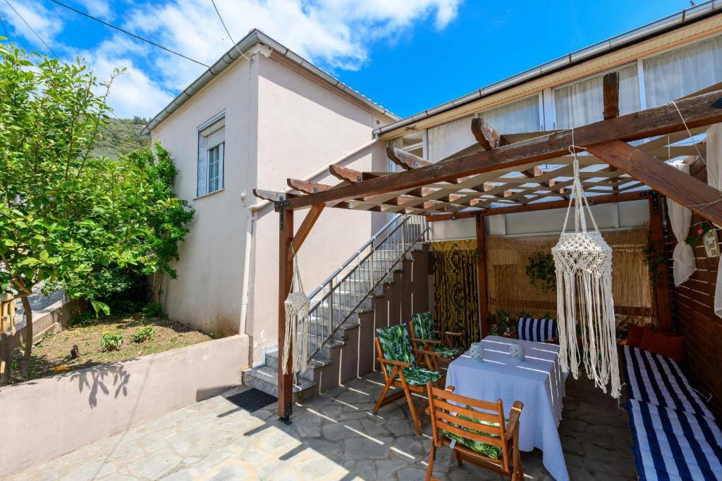 a patio with a table and chairs under a pergola at Adamou Family House in Prinos