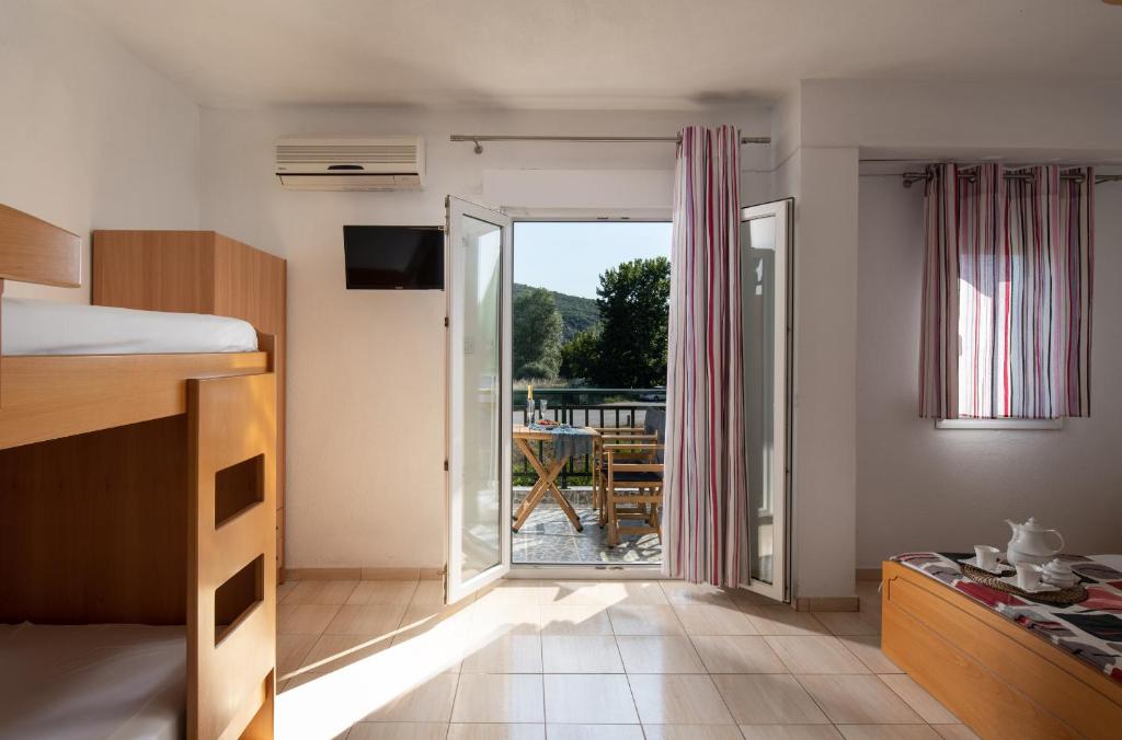 a bedroom with a bed and a view of a patio at Studios Kofos Limin in Porto Koufo