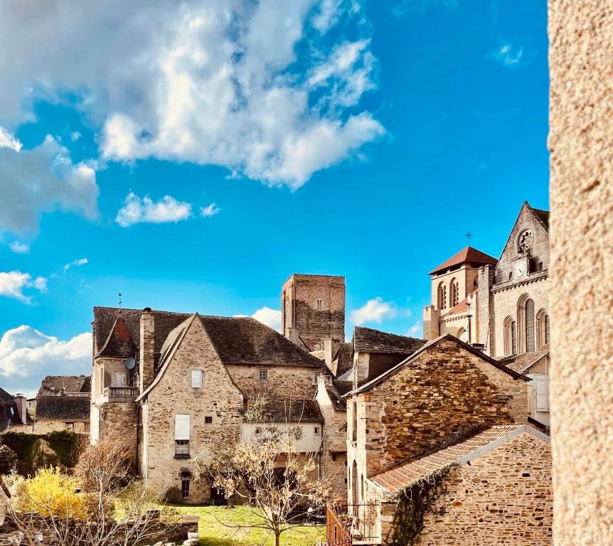 un ancien bâtiment en pierre avec un ciel bleu en arrière-plan dans l'établissement Au Bonheur Arédien, à Saint-Yrieix-la-Perche